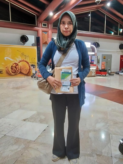 A domestic helper arriving in Malaysia with her documents, ready to begin her placement