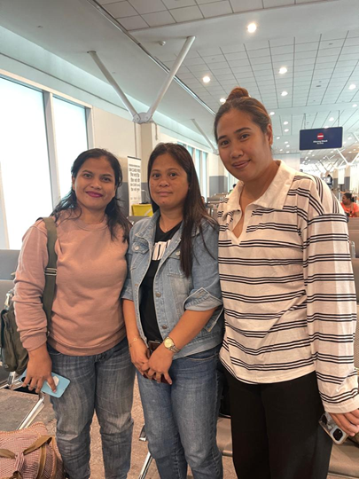 Three domestic helpers at the airport, departing for their placements in Malaysia